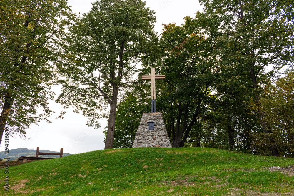 Fototapeta premium Wooden Christian religious cross on the background of green trees