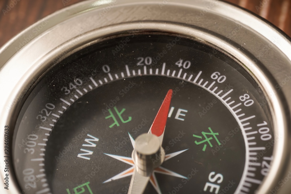 Metallic compass on wooden background Metallic compass on wooden background