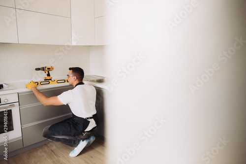 Maintenance man installing kitchen furniture