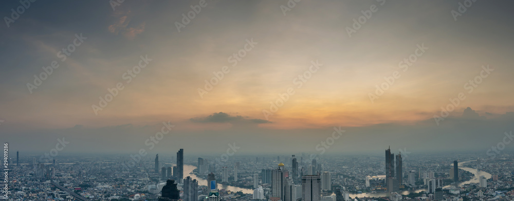 Aerial Skyline Panorama of Cityscape from Mahanakhon Skywalk and business urban downtown with Beautiful Twilight Peak at Sunset, Cityscape capital and financial district center of Bangkok, Thailand.