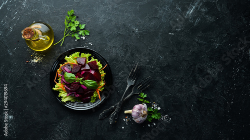 Beet salad with onions in a black plate on a black background. Top view. Free space for your text.