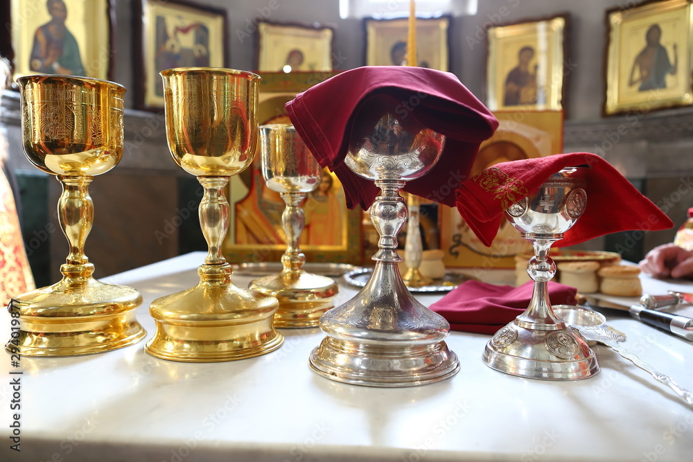 Obraz premium Orthodox churches. A silver cup for communion, a prosphora for the preparation of the sacred mystery of the Eucharist, and sweet wine on the table on the throne.