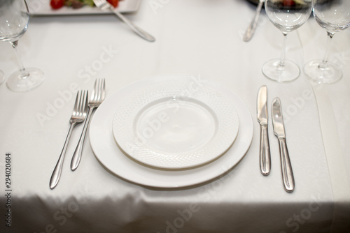 The white napkin nicely folded on the plates  serving a celebratory banquet.