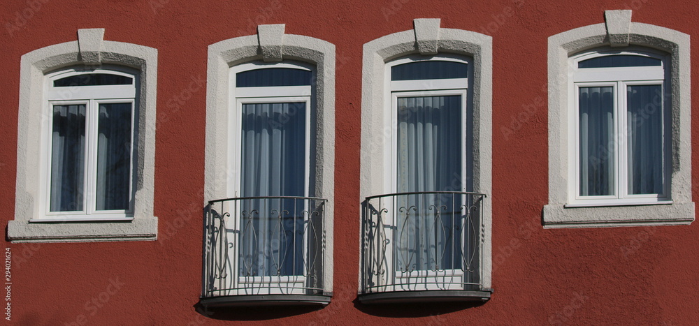 Hausfront mit verschiedenen Fenstern.
