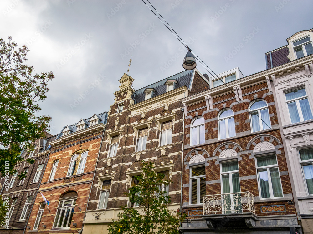 Fototapeta premium Beautiful old Maastricht urban architecture in Netherlands, exterior low-angle partial view under overcast summer sky