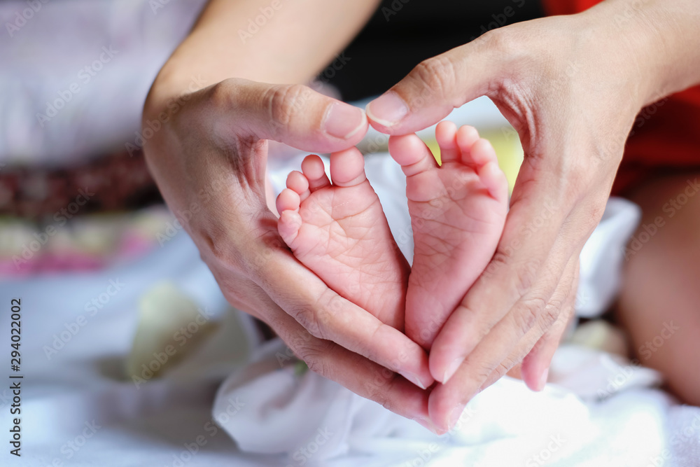 Parent holding in the hands feet of newborn baby. Parent holding in the hands feet of newborn baby.