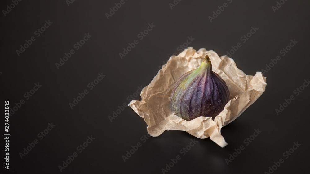 Lone figs in craft packaging on a black background Lone figs in craft packaging on a black background