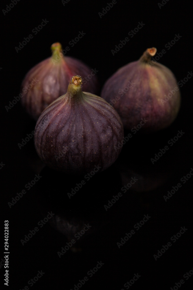 Fototapeta premium Ripe figs with reflection on black glass