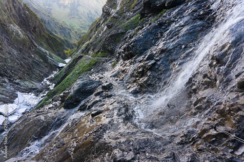 Waterfall drops directly on a hiking path E5 transalp from oberstdorf to kemptner hut