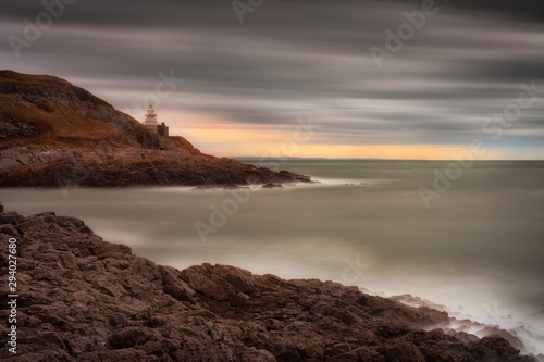 High tide exposing the rocks around Mumbles Lighthouse on the Gower peninsula in Swansea, South Wales, UK.