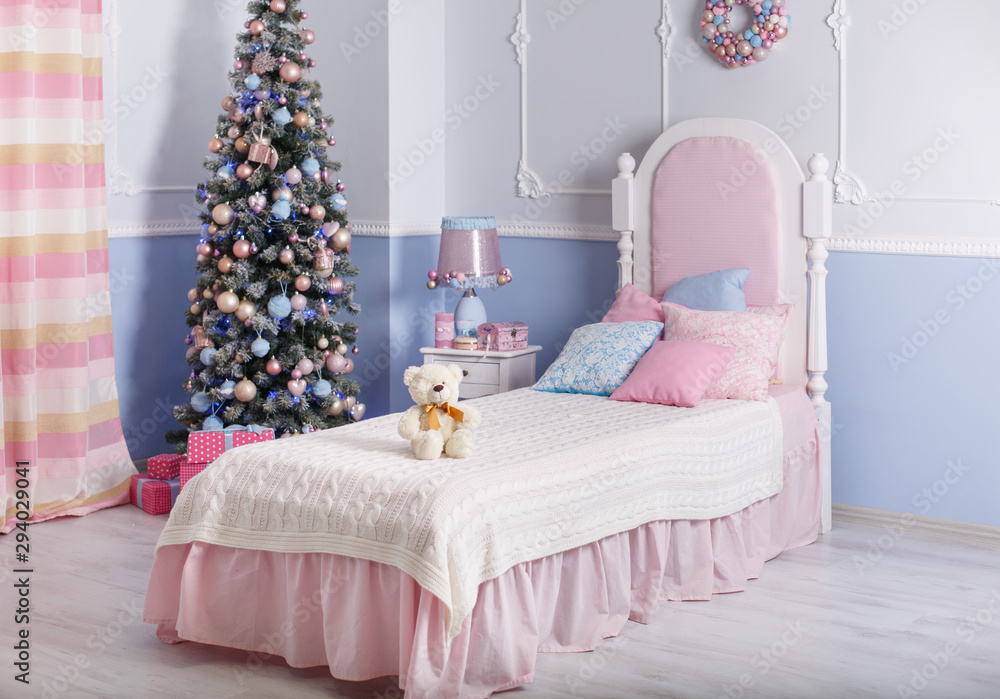 New year decoration in the bedroom in tender pink and blue colors. Stylish Christmas interior with white bed. Comfort home.