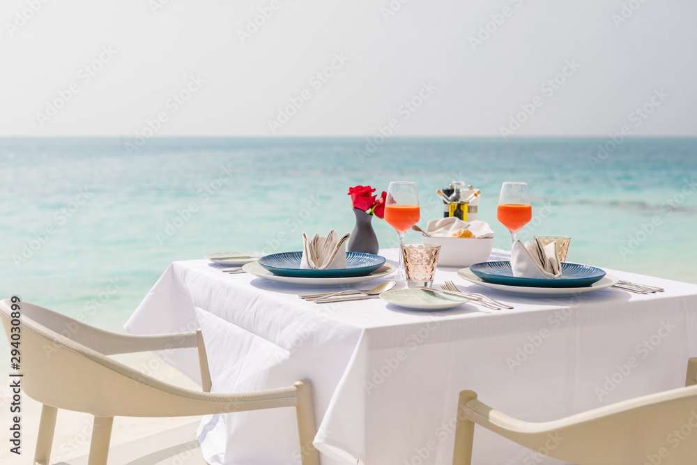 Fresh breakfast in a beautiful location with sea views. Luxury summer vacation or honeymoon destination. Table with gourmet delicious food near the sea with horizon. Beautiful summer breakfast setting