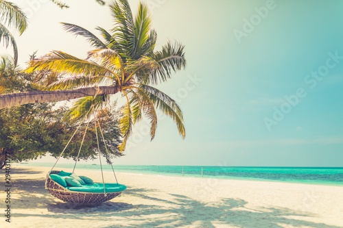 Tropical beach background as summer landscape with beach swing or hammock and white sand and calm sea for beach banner. Perfect beach scene vacation and summer holiday concept. Vintage style effect