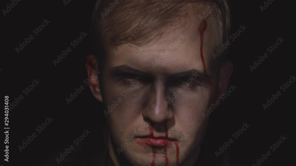 Halloween man portrait. Guy with dripping blood on his face. Scary makeup Halloween man portrait. Guy with dripping blood on his face. Scary makeup