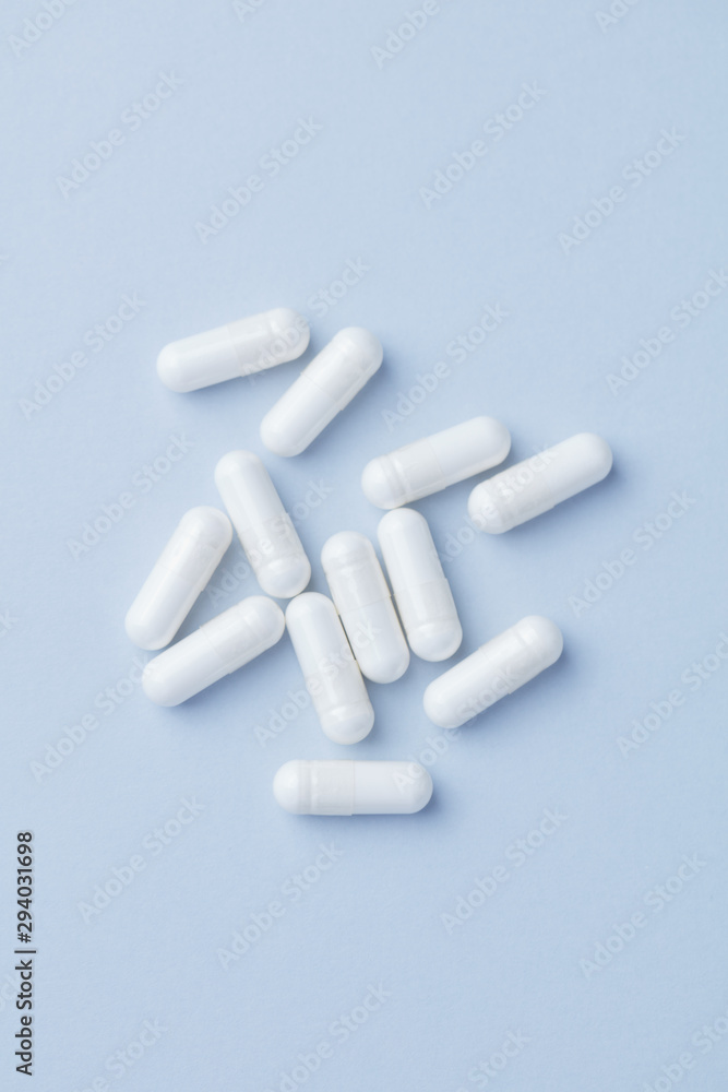 Arginine capsules. Bright paper background. Top view. Copy space. Arginine capsules. Bright paper background. Top view. Copy space.