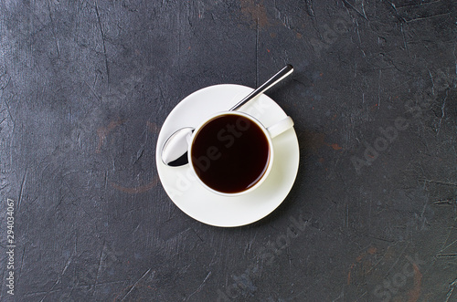 Cup of coffee on a saucer on a dark background. The view from the top.