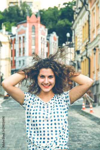 Young pretty girl walking down the street at sunshine