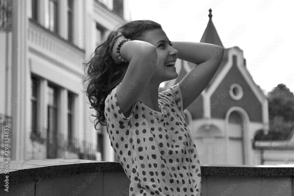 Young pretty girl walking down the street at sunshine