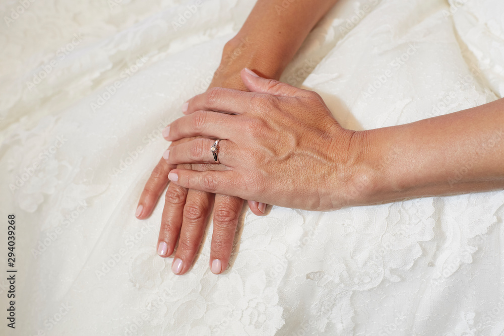 Woman's hands on top of her wedding dress. Woman's hands on top of her wedding dress.