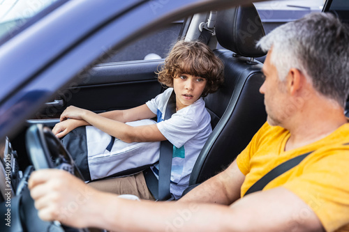 Little boy sitting near his mature father in the car