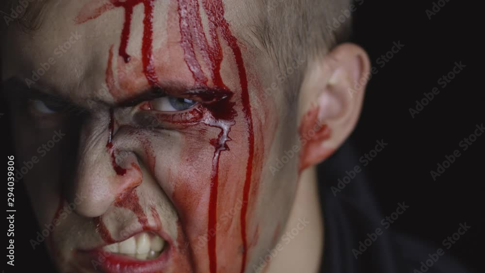 Halloween man portrait. Guy with dripping blood on his face. Scary makeup Halloween man portrait. Guy with dripping blood on his face. Scary makeup