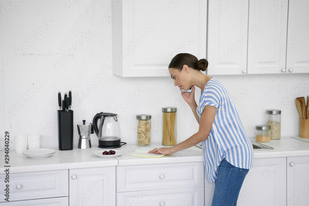Busy woman talking on the phone and reading notes stock photo Busy woman talking on the phone and reading notes stock photo