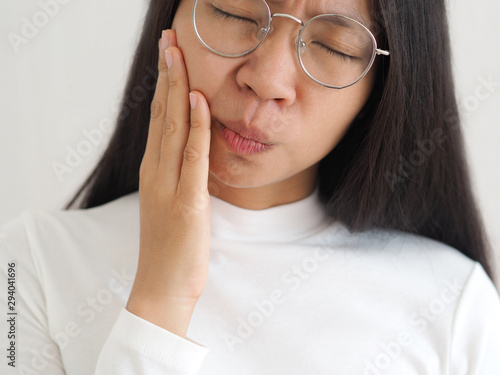 Konstfotografi trigeminal neuralgia and temporomandibular joint and muscle disorder in asian woman, She use hand touching her cheek and symptoms fo pain and suffering on isoleted white background