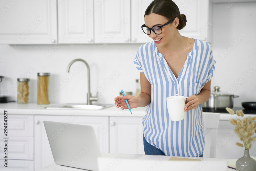 Delighted lady with coffee looking at laptop stock photo Delighted lady with coffee looking at laptop stock photo