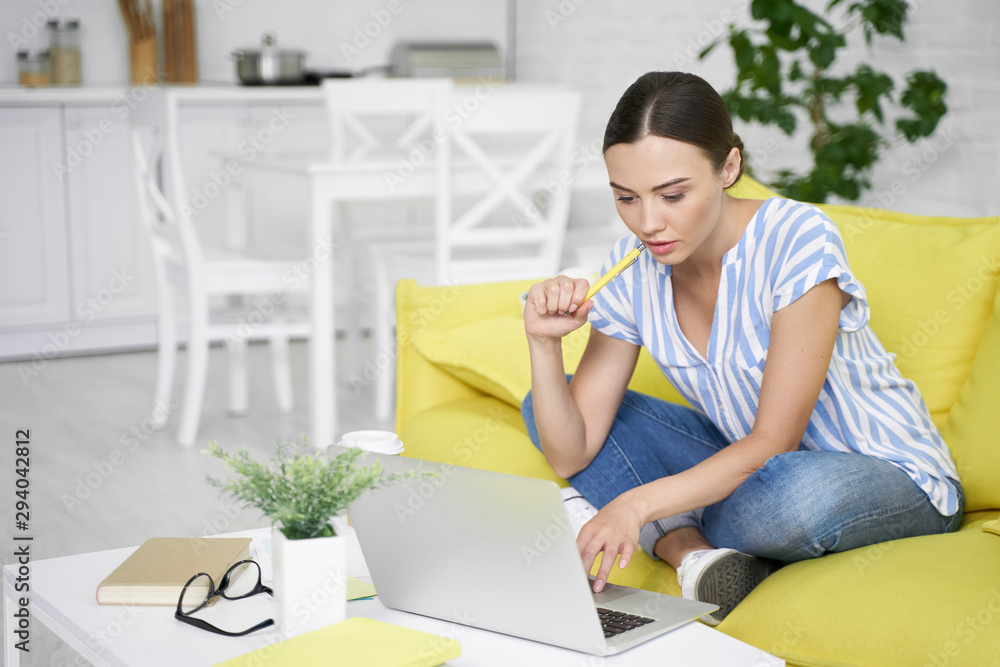Thoughtful freelancer on the sofa with the laptop stock photo Thoughtful freelancer on the sofa with the laptop stock photo