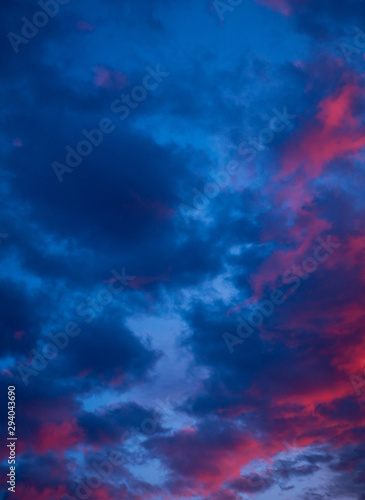 Sky during sunset with red clouds. A beautiful sunset with a reflection of red on the background of the setting sun. Background with clouds.