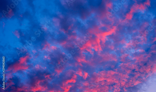 Sky during sunset with red clouds. A beautiful sunset with a reflection of red on the background of the setting sun. Background with clouds.