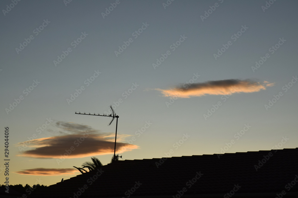 Obraz premium Nuages isolés au-dessus des toits et des antennes de télévision