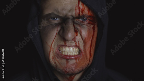 Man executioner Halloween makeup and costume. Guy with blood on his face © Andrii Iemelianenko