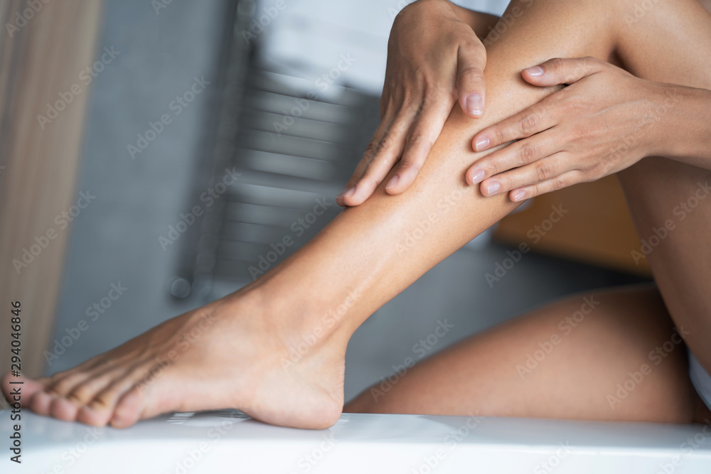 Female applying a lotion on the leg Female applying a lotion on the leg