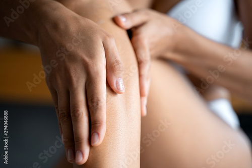 Caucasian woman applying a body lotion on her skin