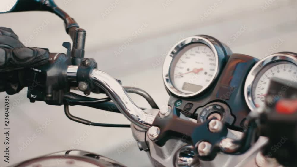 Motorcycle ignition action. Motorcyclist inserting the key and starting the engine Motorcycle ignition action. Motorcyclist inserting the key and starting the engine