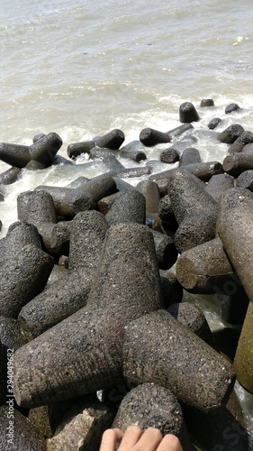 water splashing on stones on the beach of Marine drive, Mumbai 