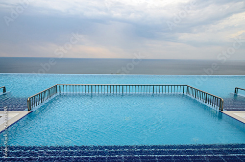 Infinity pool with crystal blue water view to sea  ocean © Negoi Cristian