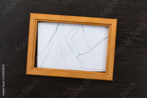 Broken glass photo frame on a wooden table