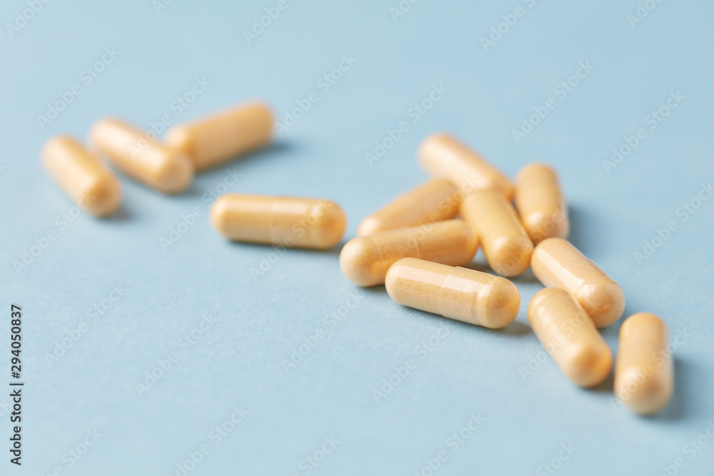 Coenzyme Q10 capsules. Dietary supplements. Bright paper background. Close up. 