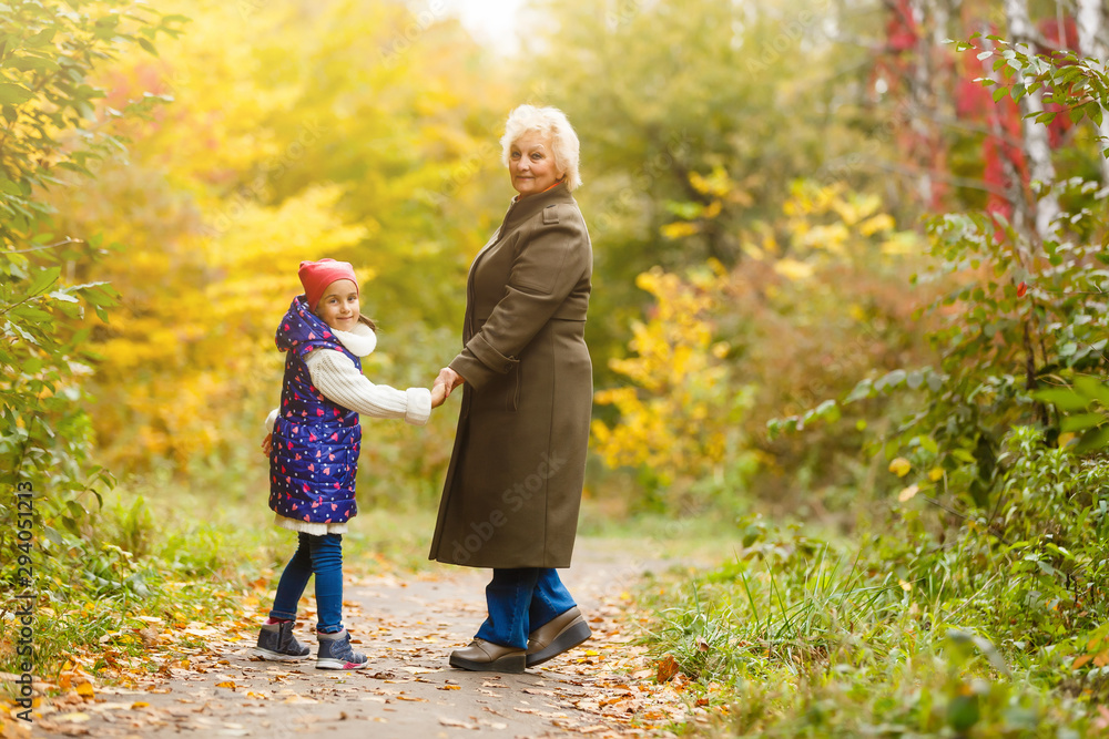Grandmother and her granddaughter picking berries in the forest Grandmother and her granddaughter picking berries in the forest