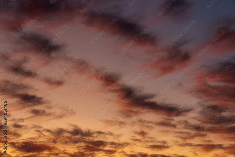 Fototapeta premium Sunset with cloudy sky, cirrus clouds, blues, oranges, yellows and pinks, nature background