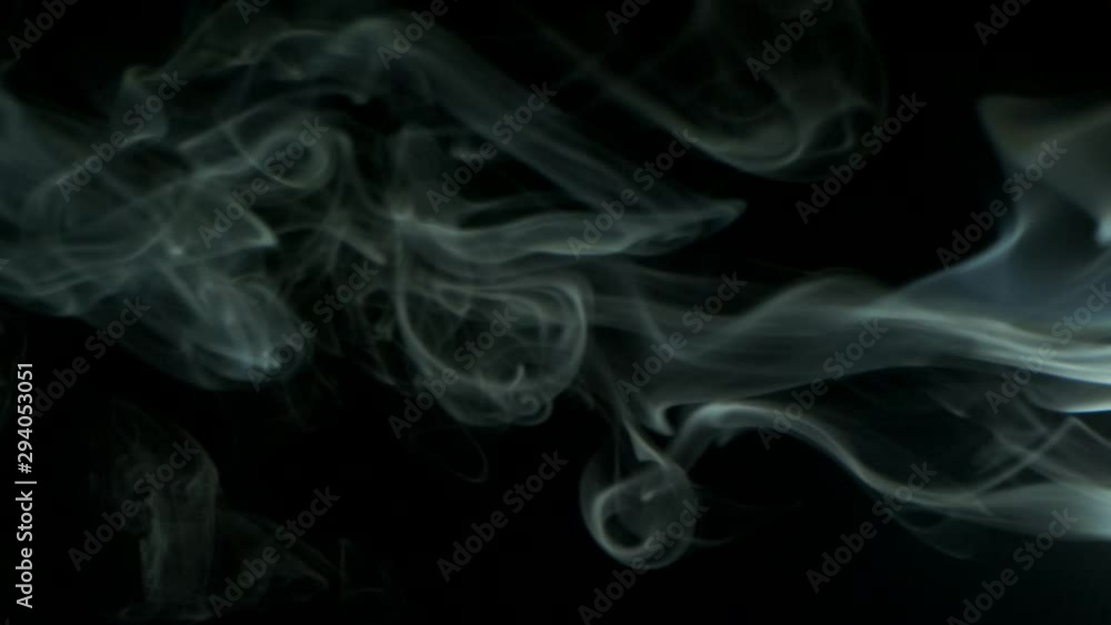Slow motion, Vertical video screensaver - Trickle silvery smoke slowly rising graceful twists upward. Cigar smoke blowing from the right side. Closeup, isolated on black background. Slow motion, Vertical video screensaver - Trickle silvery smoke slowly rising graceful twists upward. Cigar smoke blowing from the right side. Closeup, isolated on black background.