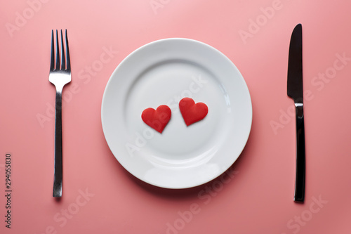 Two hearts in plate with cutlery. Romantic dinner in restaurant concept. Meeting of lovers at wedding reception. photo