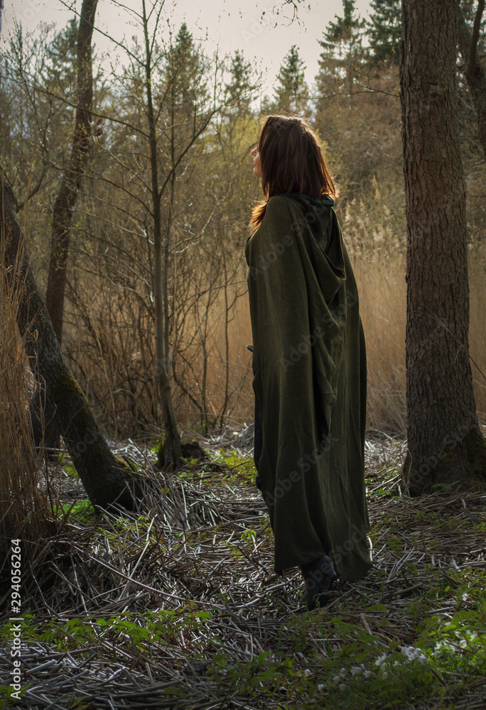 Young witch with green gloak stay in forest Young witch with green gloak stay in forest