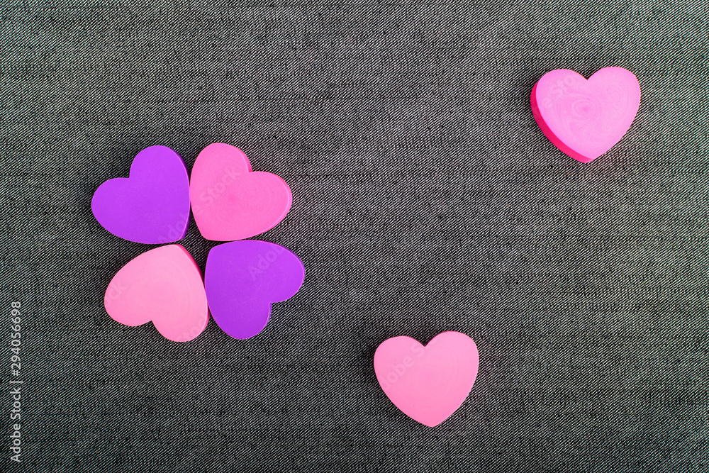 Obraz premium Six pink and mauve hearts on dark grey textile background, top view with space for text above, selective focus