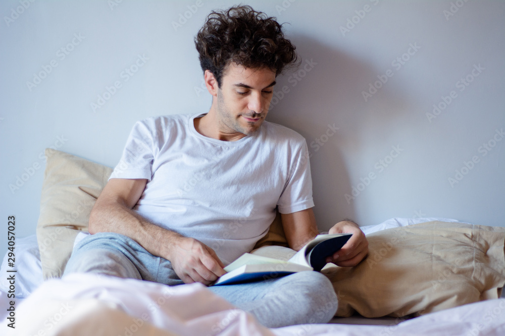 Man reading a book in bed