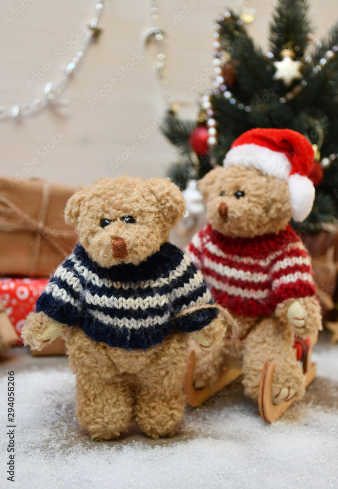 A Teddy Bear takes another one for a sledge drive on a background of a Christmas tree & boxes with Christmas presents A Teddy Bear takes another one for a sledge drive on a background of a Christmas tree & boxes with Christmas presents