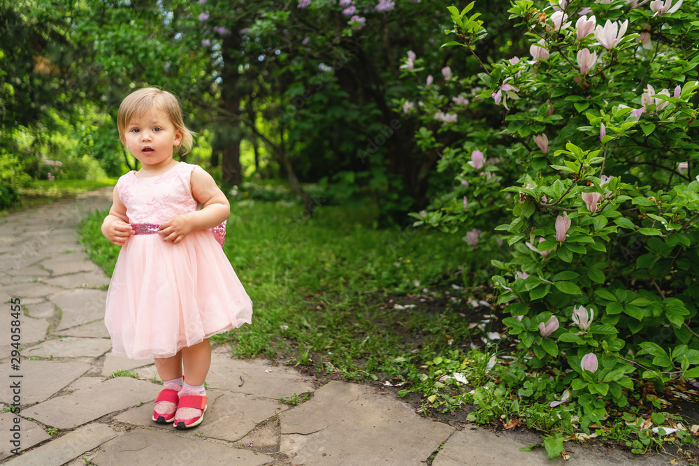 Kid girl posing at spring garden. Looking at camera. Childhood. Kid girl posing at spring garden. Looking at camera. Childhood.