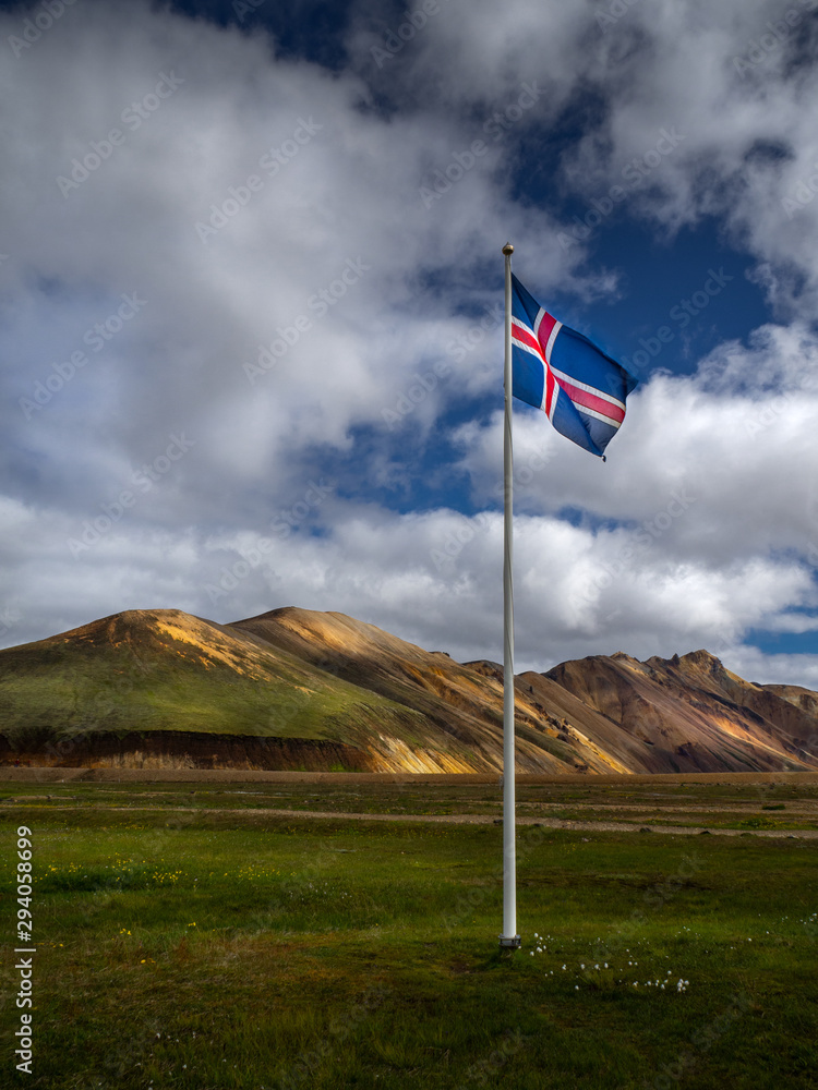 Icelandic flag against the backdrop of the Landmannalaugar mountains